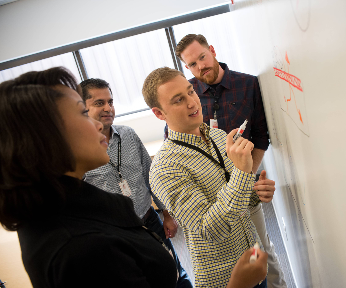 People writing on a whiteboard