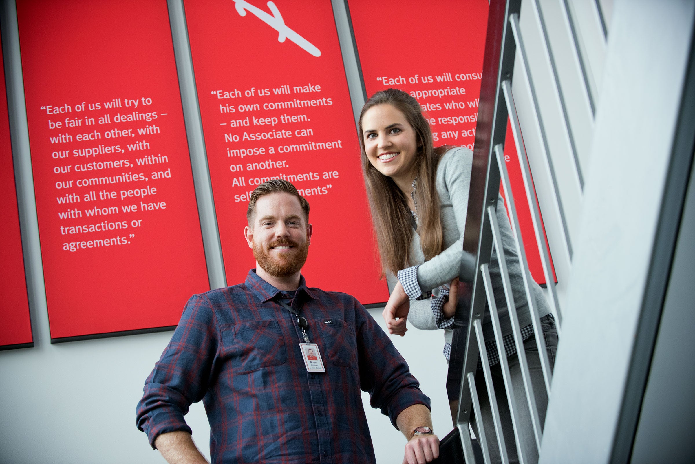 Two associates standing near Gore's principles signs